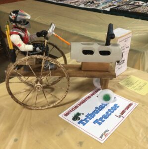 Back wheels are from an antique baby carriage. Steering wheels is a mason jar lid,